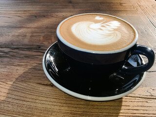 Hot mocha coffee or cappuccino in the blue cup with luxury pattern on the wooden table