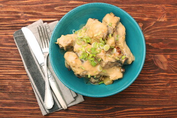 Chicken drumsticks in a bowl under creamy sauce