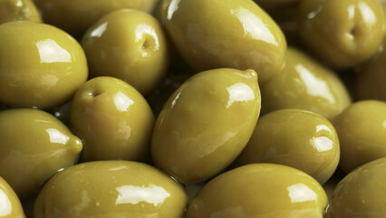 Large shiny green olives macro background
