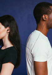 Unrecognizable white woman and black man listen music. International couple, togetherness, one earphones for two people, unity concept