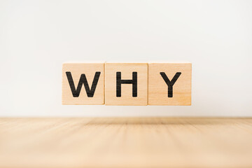 Surreal abstract geometric floating wooden cube with vocabulary "WHY" on wood floor and white background