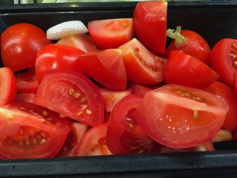 Many tomatoes are placed in a salad bar.