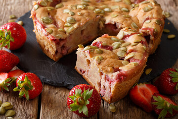 Banana strawberry pie with pumpkin seeds close-up on a table. Horizontal
