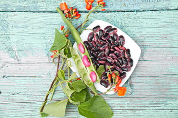 декоративная фасоль  на деревянной поверхности и цветы 