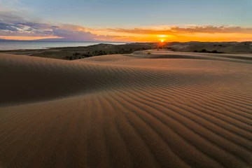 Fototapeten Picturesque desert landscape with a golden sunset over the dunes © Anton Petrus