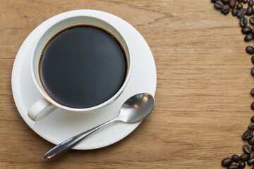 A cup of black coffee on wood background.