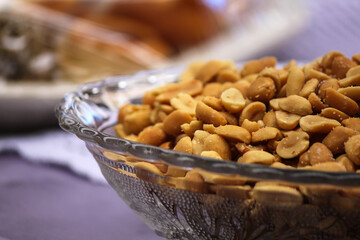 Macro photo of glass bowl with salted peanuts