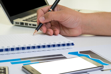 close up side view businessman holding pen for writing on note book  for financial; accounting; analyst; TAX concept.