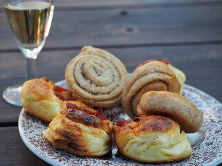 Homemade scones on plate and glass of wine on wooden background.