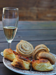 Homemade scones on plate and glass of wine on wooden table.