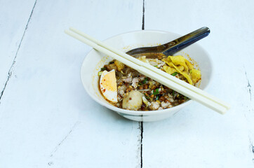 Delicious spicy Thai Noodles with pork on wooden table