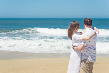 Fototapeta na wymiar Young romantic couple hugging on the beach