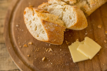 Baguete and slices of cheese on cutting board