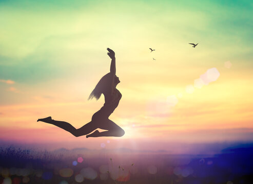 International human rights day concept: Silhouette of a girl jumping at autumn sunset mountain with her hands raised