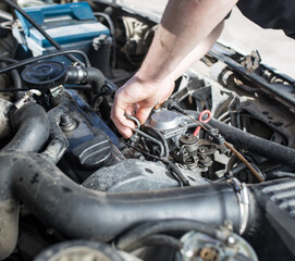 The master repairs under the hood of the car