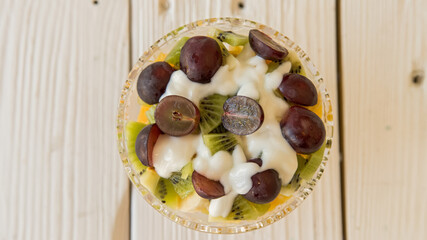 Bowl of healthy fresh fruit salad with cream