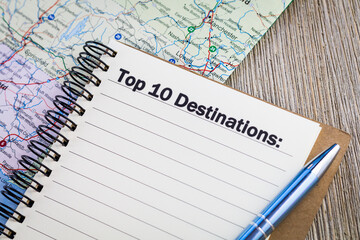 Top 10 destinations  concept on notebook with map and wooden board