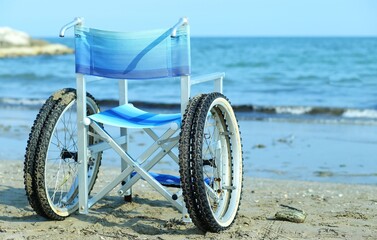 wheelchair by the sea in summer with large wheels
