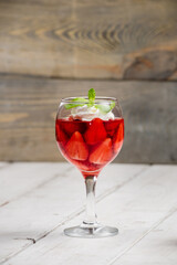 Strawberry jelly, strawberry and ice cream with mint in a glass on a wooden table, country style