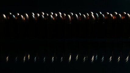 Bullets on the black mirror floor. Bullets are a projectile expelled from the barrel of a firearm.