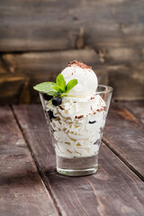 Ice cream with whipped cream, blueberries, mint and strawberry jam