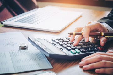Businessman's hands with calculator and cost at the office and Financial data analyzing counting on...