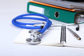 Folder file, stethoscope and RX prescription on the desk. blurred background.