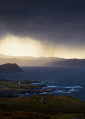 Fototapeta na wymiar Heavy rain over coastal crofts at Loch Ewe, Scottish Highlands, Scotland, UK.