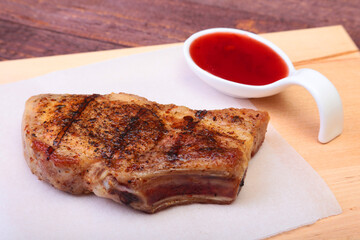 grilled pork chop with Cranberry sauce on plate on wooden board