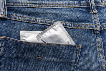 Condom silver color in the pocket of a blue jeans