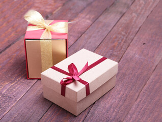 red and gold gift box on wood background.