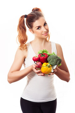 portrait of smiling young woman holding fresh spring vegetables.