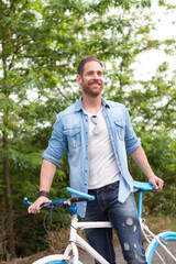 Handsome man with enjoying with his bike in the park