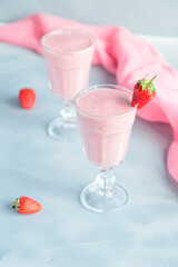 Fresh and Cold Strawberry Smoothie in Tall Glasses on Grey Background 