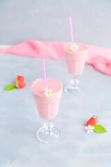Fresh and Cold Strawberry Smoothie in Tall Glasses on Grey Background 