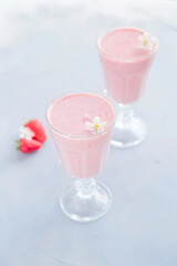 Fresh and Cold Strawberry Smoothie in Tall Glasses on Grey Background 