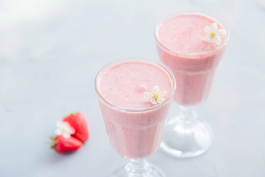 Fresh and Cold Strawberry Smoothie in Tall Glasses on Grey Background 