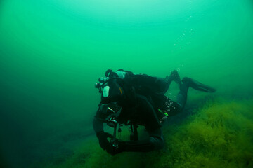 Fototapeta na wymiar Diver floats under the water