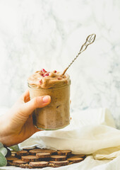 Beautiful woman holding in her hand glass jar of chocolate icecream. Tone.