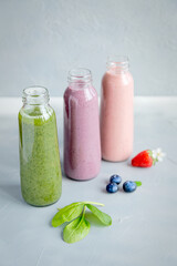 Variations of Smoothies in Bottles on Grey Background Healthy Drink