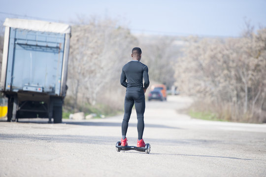 Black male riding hoverboard