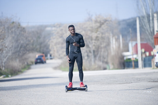 Black male riding hoverboard