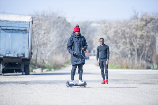 Two black men riding hoverboard