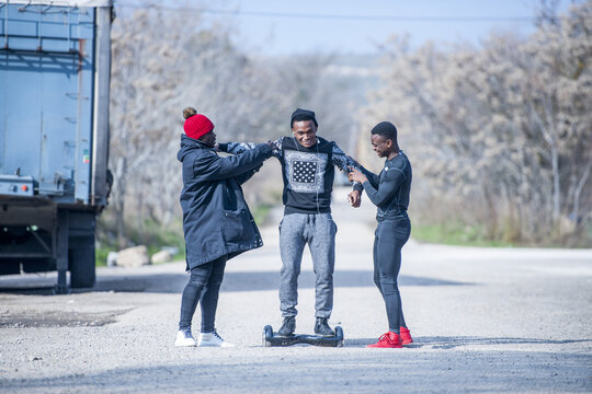 Three black men riding hoverboard