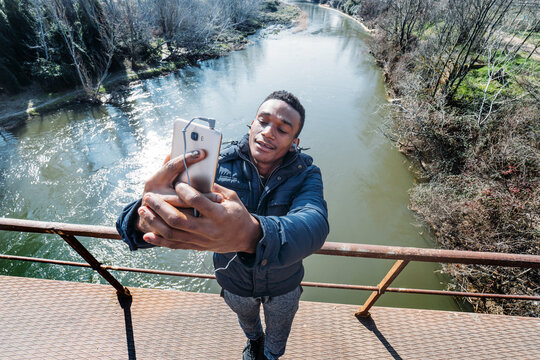 Young Male Taking Selfie On Bridge