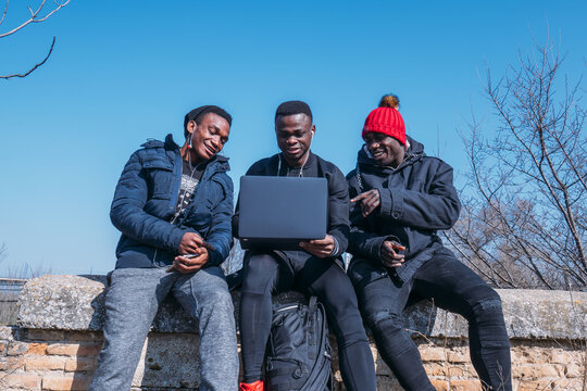 Friends using laptop outdoors