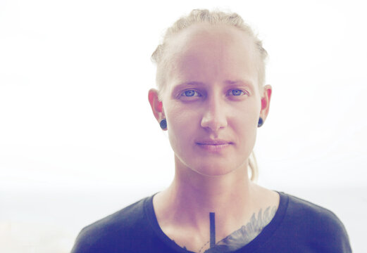 Beautiful young woman with tattoe and tunels, head shot, look in camera. Alternative style and human beauty.