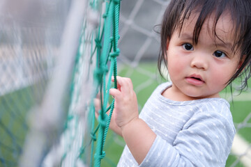Cute asian girl playing on football field. Portrait of Asian beautiful baby girl of 1 year and 3 months old.
