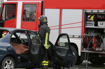 Fototapeta premium Destroyed car and fire truck during a mission