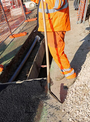 man with high visibility clothing while working for laying techn